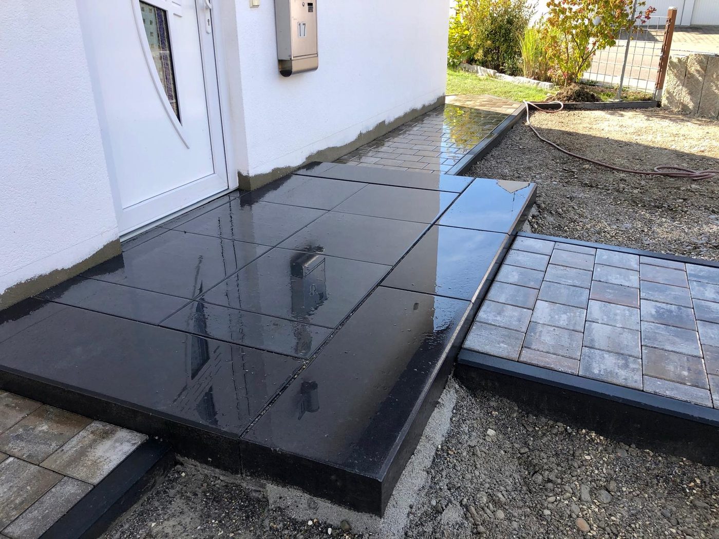 Hauseingang mit anthrazit Pflasterung, Granitstufe und Vordach